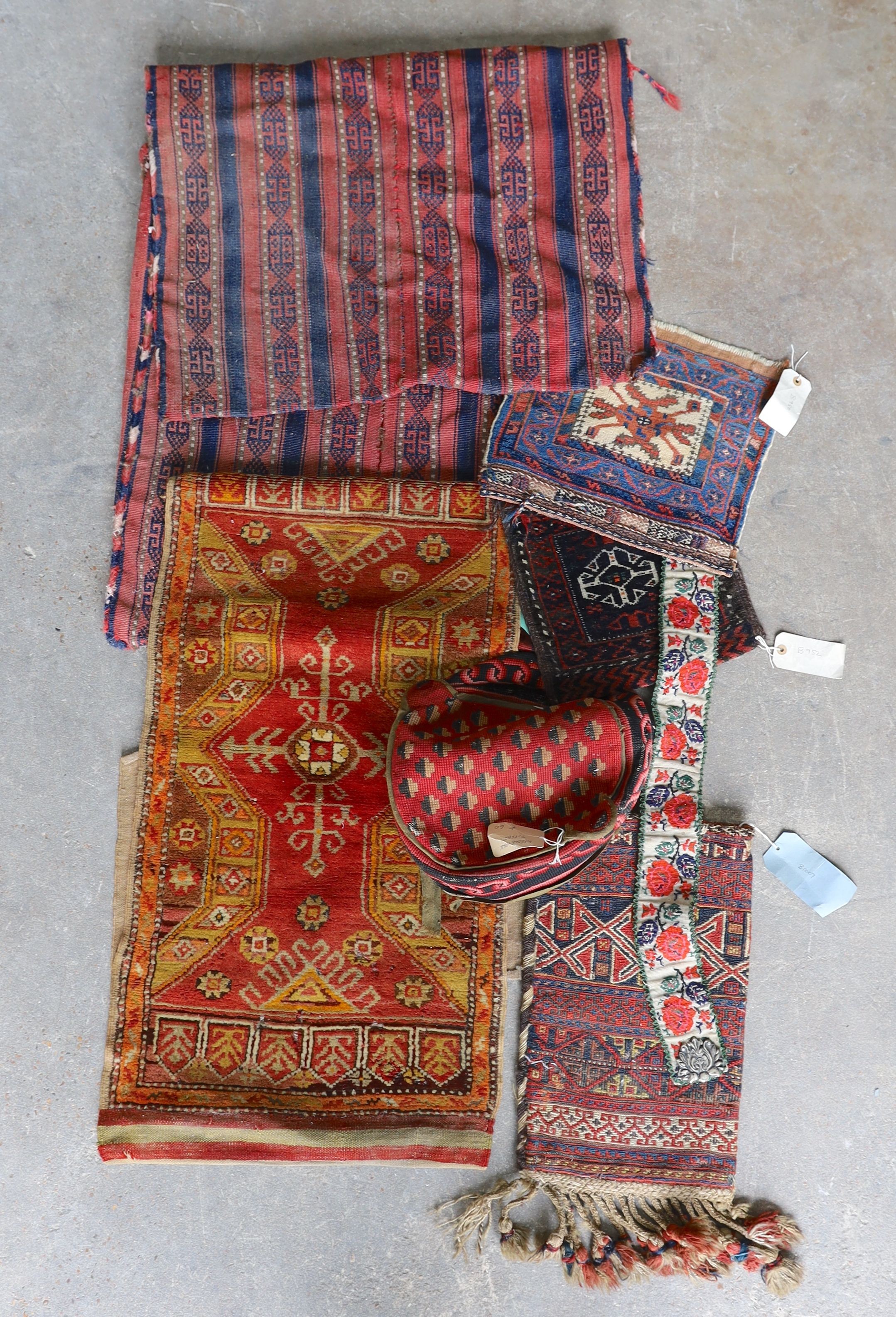 An Afghan Kilim flatweave saddlebag, 144 x 69cm together with six assorted bags, faces, etc.